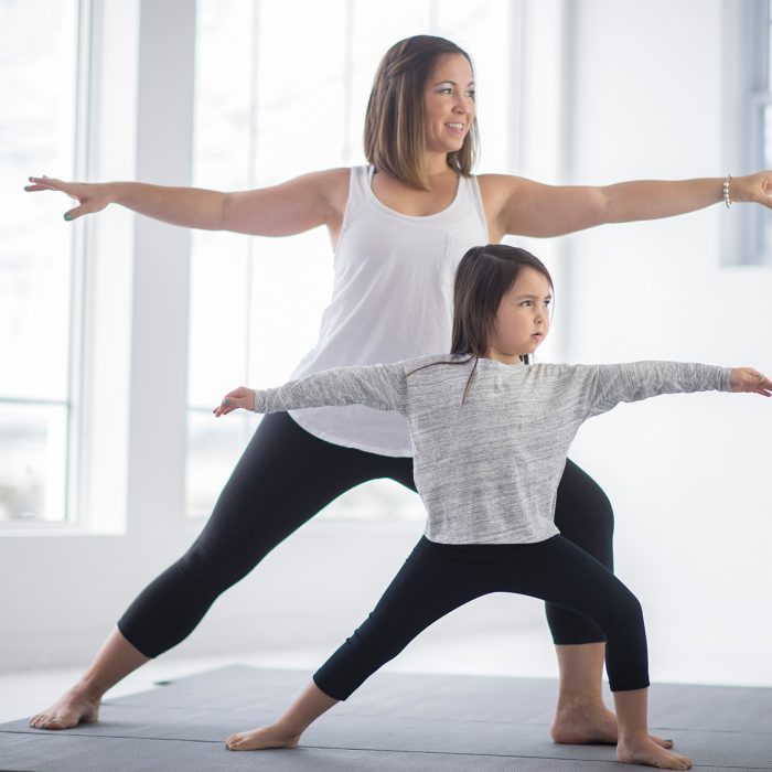 mom teaching daughter how to stretch her back