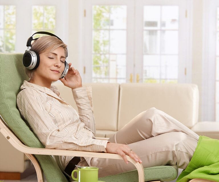 Woman sitting on a chair listening to Relaxation Therapy.