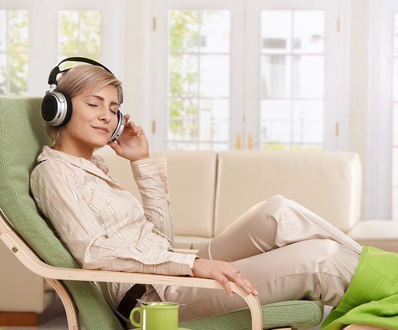 Woman sitting on a chair listening to Relaxation Therapy.